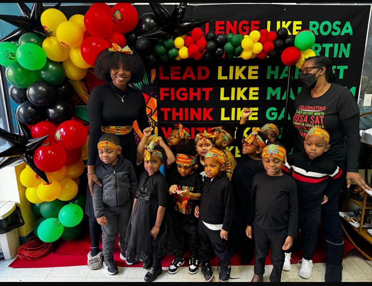Children and teachers celebrating Black History Month with traditional headwraps and decorations