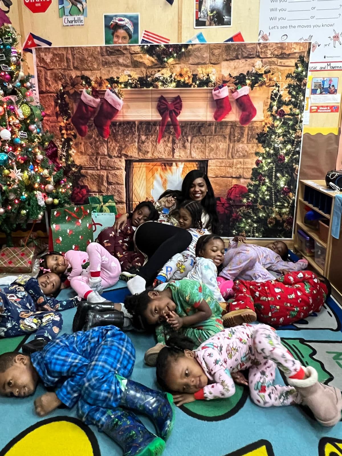 Children in pajamas gathered with their teacher for a cozy Christmas celebration