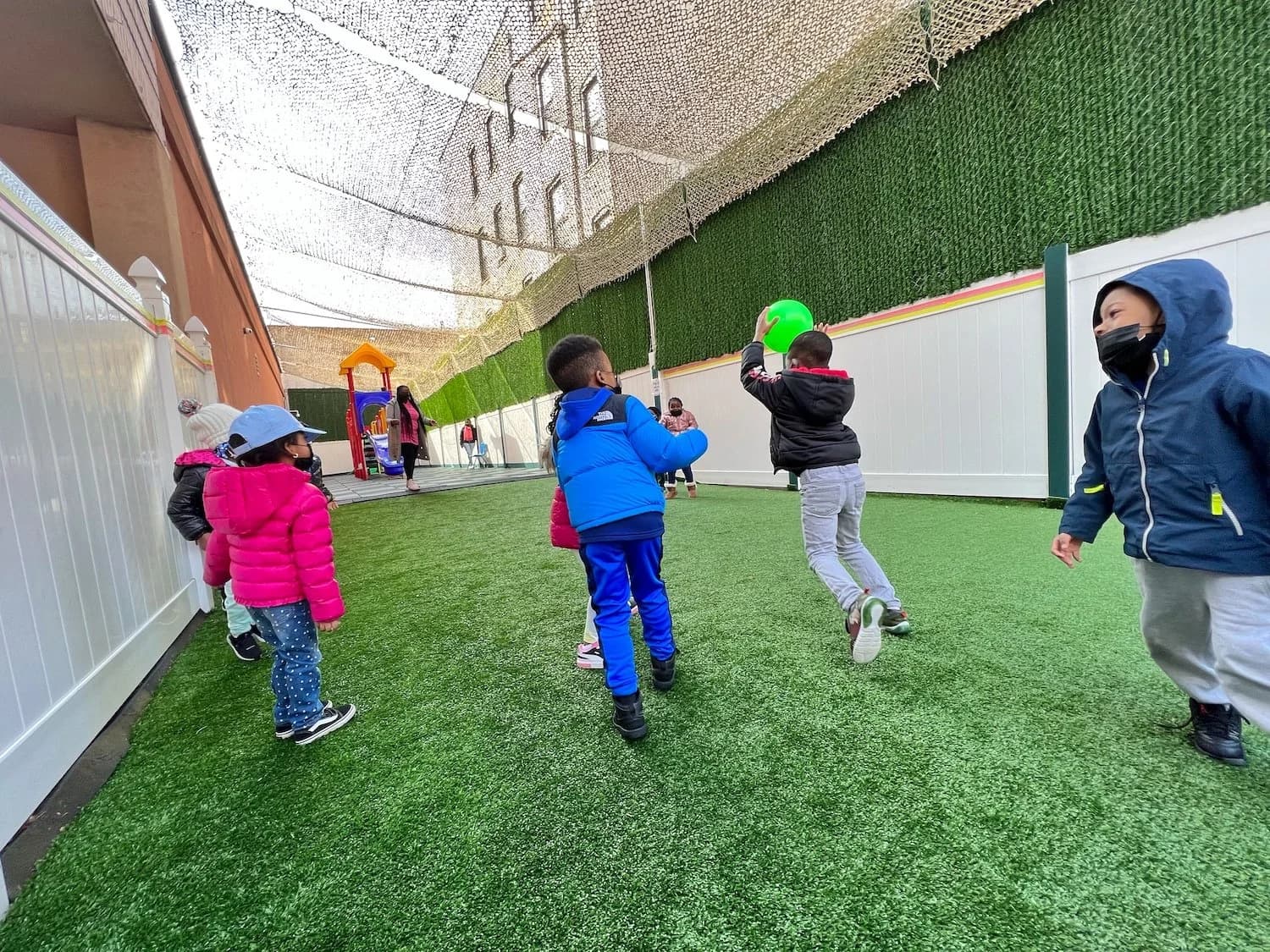Children playing a ball game on the outdoor turf play area