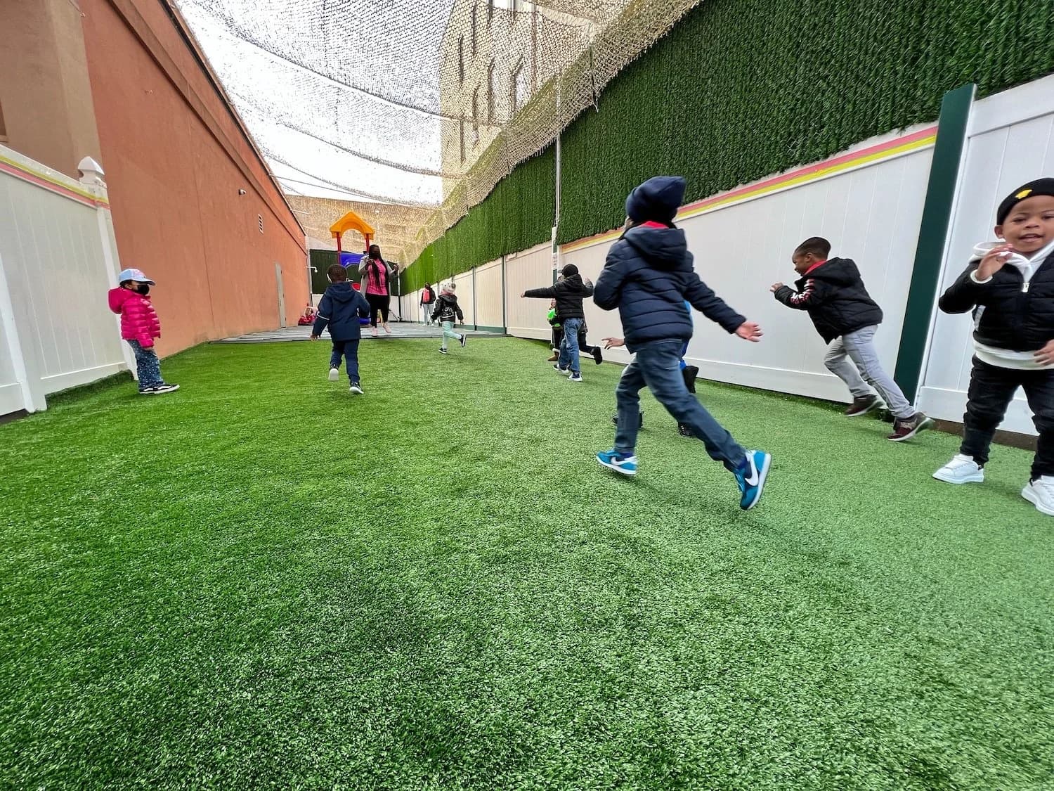 Toddlers and preschoolers running and playing outdoors at Einstein Daycare in East Flatbush Brooklyn